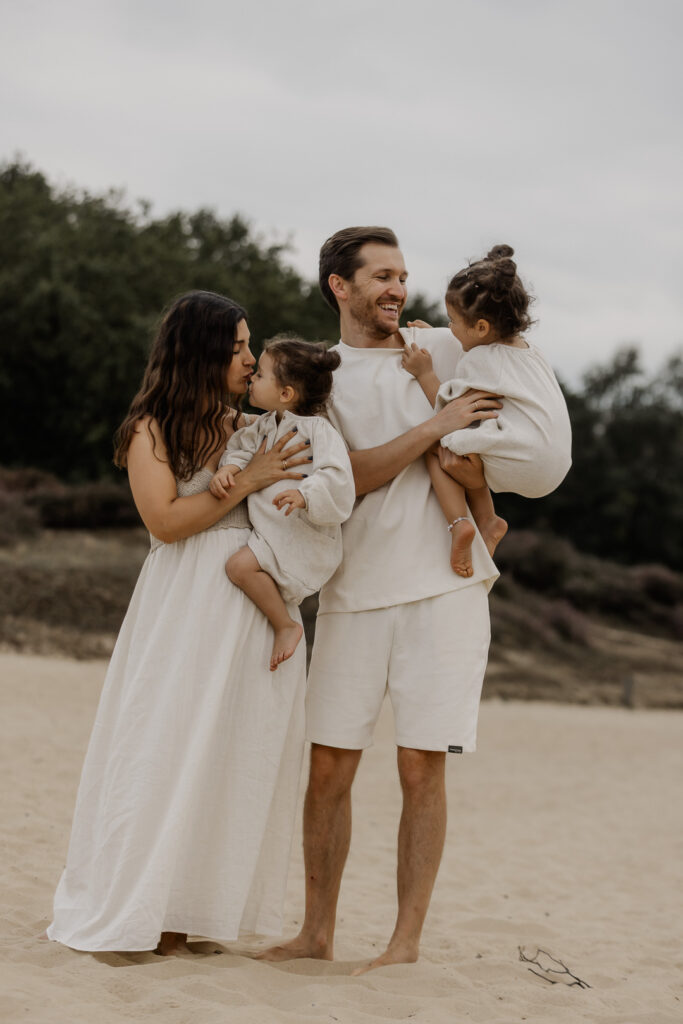 Eltern mit zwei Kindern auf dem Arm stehen in den Boberger Dünen in Hamburg