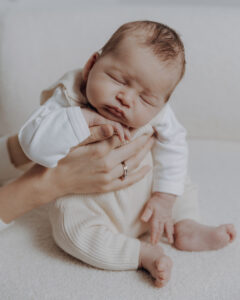 Neugeborener Junge in den Händen seiner Mama